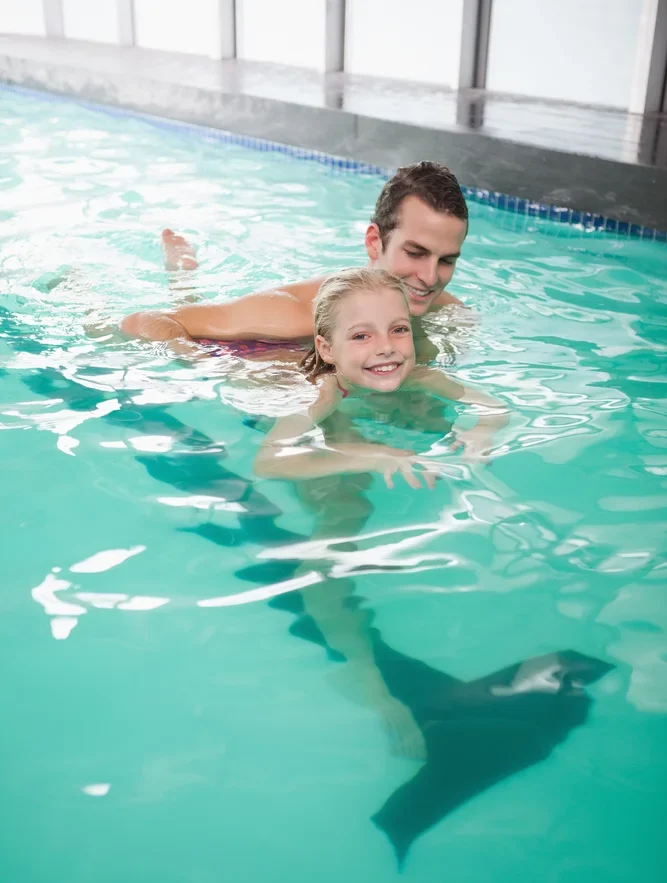 Cute Little Girl Learning To Swim With Coach