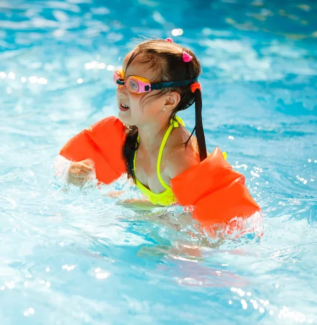 A Child Wearing Zoggs Float Bands In A Swimming Pool